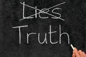 Crossing out Lies and writing Truth on a blackboard.